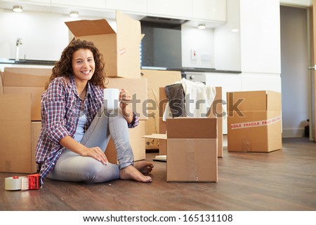 Woman Moving Into New Home And Unpacking Boxes
