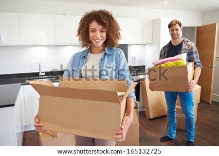 Couple Moving Into New Home And Unpacking Boxes