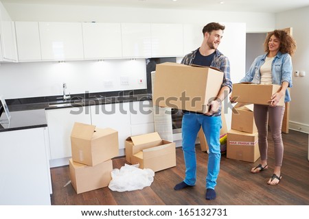 Couple Moving Into New Home And Unpacking Boxes