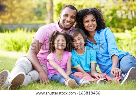 African American Family Sitting In Garden