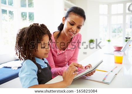 Mother And Child Using Digital Tablet For Homework