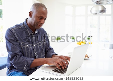 African American Man Using Laptop At Home