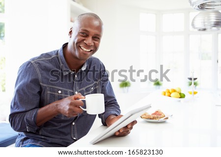 African American Man Using Digital Tablet At Home