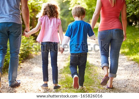 Rear View Of Family Walking In Countryside