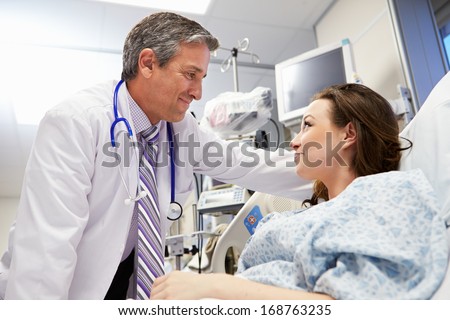 Female Patient Talking To Male Doctor In Emergency Room