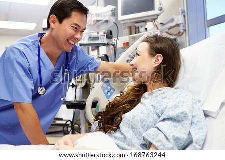 Young Female Patient Talking To Male Nurse In Emergency Room Young Female Patient Talking To Male Nurse In Emergency Room