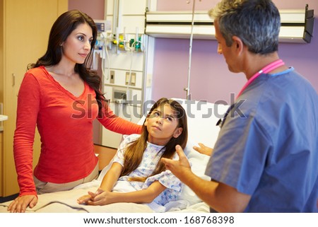 Mother And Daughter Talking To Consultant In Hospital Room