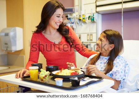 Young Girl With Mother Eating Lunch In Hospital Bed
