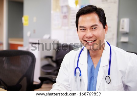 Portrait Of Doctor Working At Nurses Station