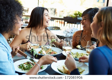 Group Of Female Friends Enjoying Meal At Outdoor Restaurant