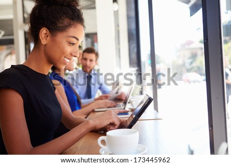 Businesswoman Using Digital Tablet In Coffee Shop Businesswoman Using Digital Tablet In Coffee Shop