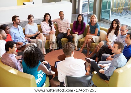 Multi-Cultural Office Staff Sitting Having Meeting Together
