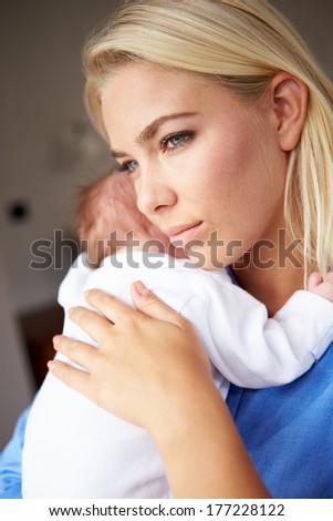 Depressed Mother Cuddling Newborn Baby