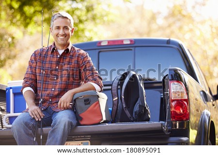 Portrait Of Man Sitting In Pick Up Truck On Camping Holiday