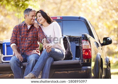 Couple Sitting In Pick Up Truck On Camping Holiday