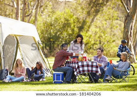Two Families Enjoying Camping Holiday In Countryside