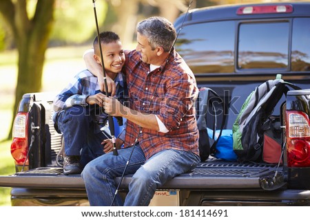 Father And Son Sitting In Pick Up Truck On Camping Holiday