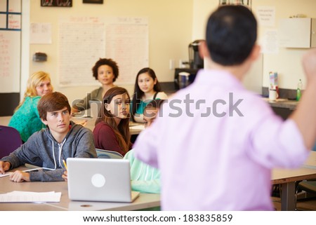 High School Students With Teacher In Class Using Laptops