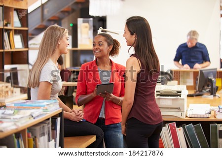 Three Female Architects Chatting In Modern Office Together