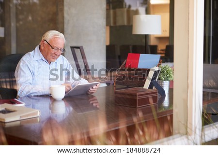 Senior Man Using Digital Tablet Through Window