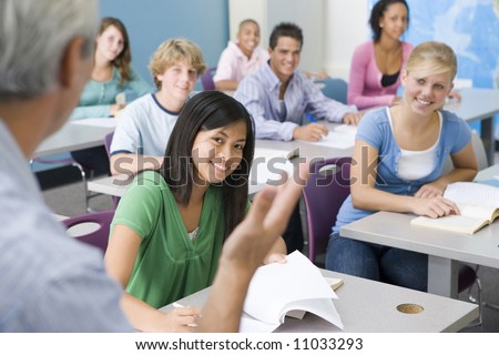 Group Of High School Students Listening To Teacher In Classroom