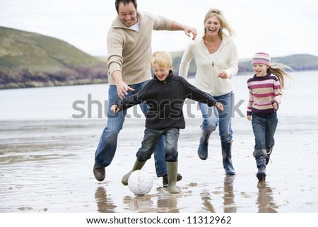 stock photo : Family playing football on beach