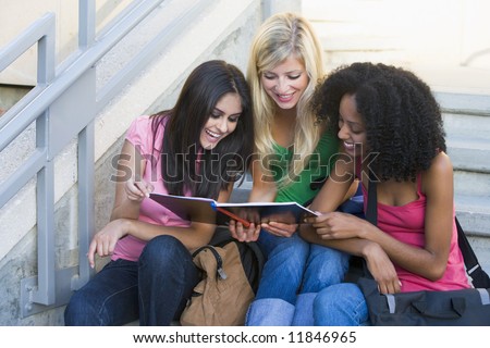 Group of three female students sitting on steps