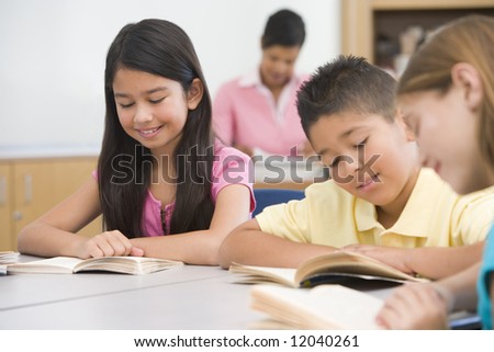 Group of elementary school pupils in class reading