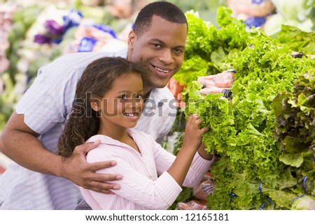 Father and daughter buying fresh produce in supermarket