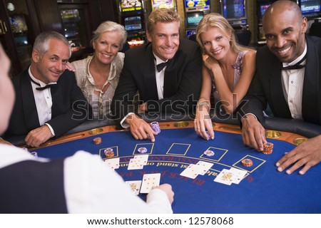 stock photo : Five people sitting around blackjack table in casino