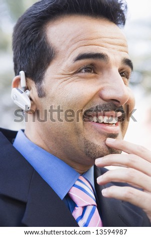 Businessman using earpiece outside