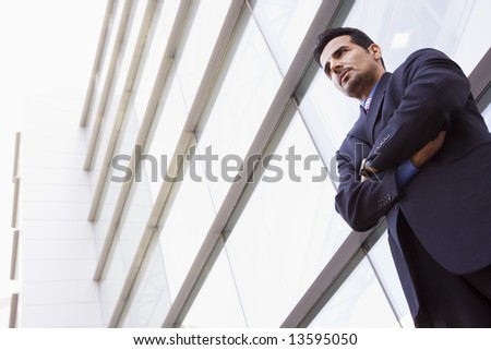 Businessman standing outside modern office building