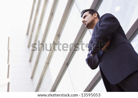Businessman standing outside modern office building