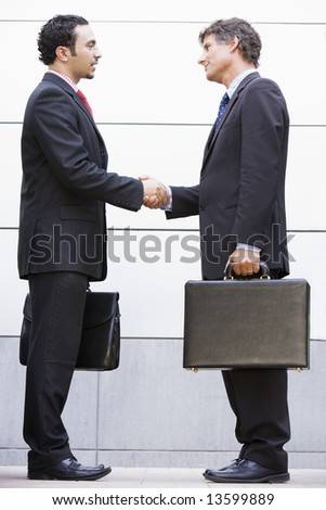 Businessmen meeting outside modern office