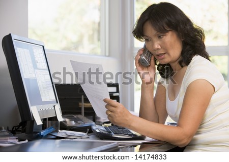 Woman in home office with paperwork using telephone
