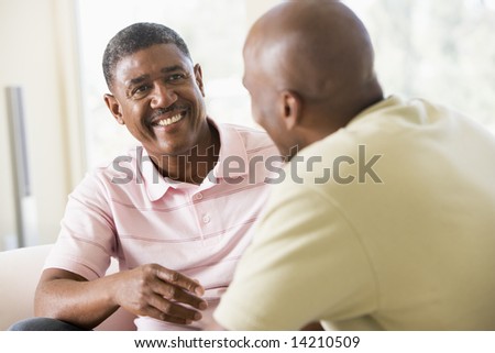 Two men in living room talking and smiling