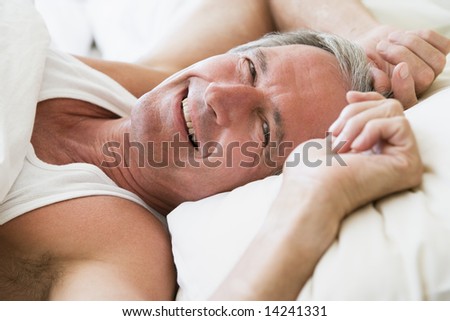 Man lying in bed smiling