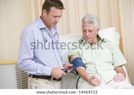 Doctor checking man\'s blood pressure in exam room