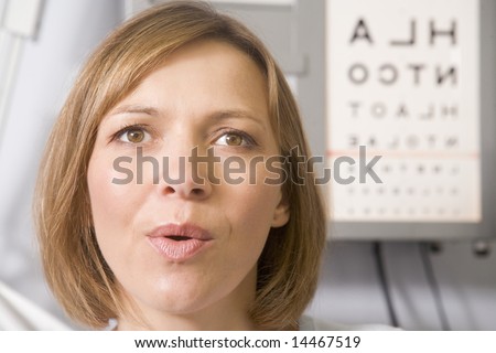 Woman in optometrist\'s exam room taking deep breath