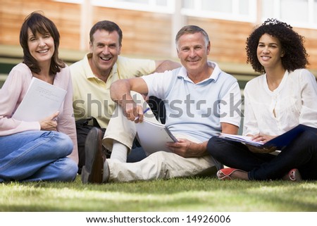 Adult students sitting on a campus lawn