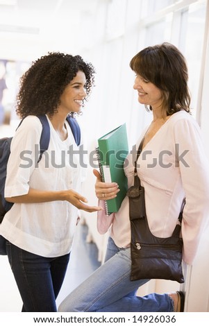 Two women students chatting in a campus corridor