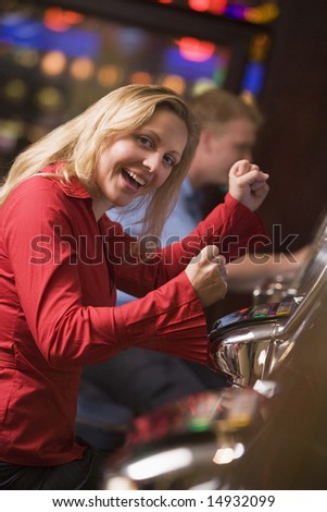 Woman celebrating win at slot machine in casino