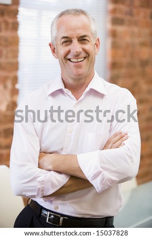 Businessman standing in office laughing