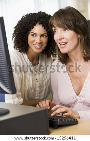 Two female adult students working on a computer together