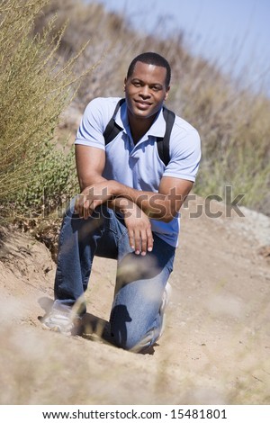 Man crouching on path to beach smiling