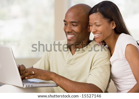 stock photo : Couple in living room using laptop and smiling