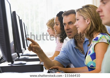 Teacher assisting college student in a computer lab