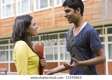 Male and female college students talking on campus