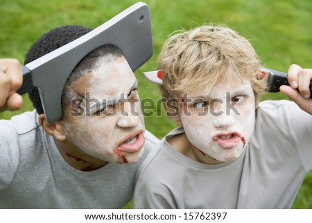 Two young boys with scary Halloween make up and plastic knives through their heads