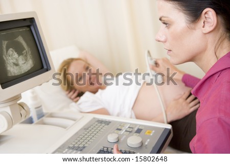 Pregnant woman getting ultrasound from doctor